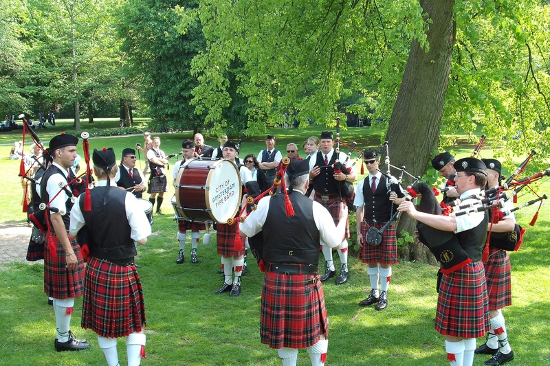 tree, crowd, uniform, outdoors, leisure activity, scottish, land, day, real people, plant, artist, bagpipes, music, group of people, clothing, men, nature