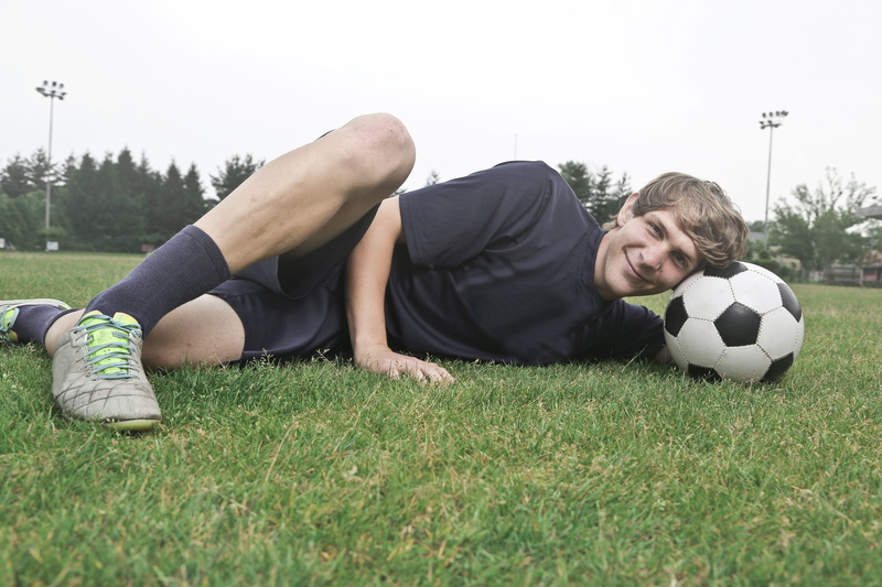 smiling, sports clothing, soccer, soccer ball, teen, grass, recreation, fun, team sport, game, soccer player, field, lawn, nature, wearing, daylight, football player