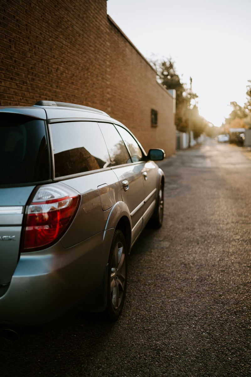 mode of transportation, sports car, silver, motor vehicle, bumper, car, built structure, coupe, limo, suv, parked, machine, gravel, day, building exterior