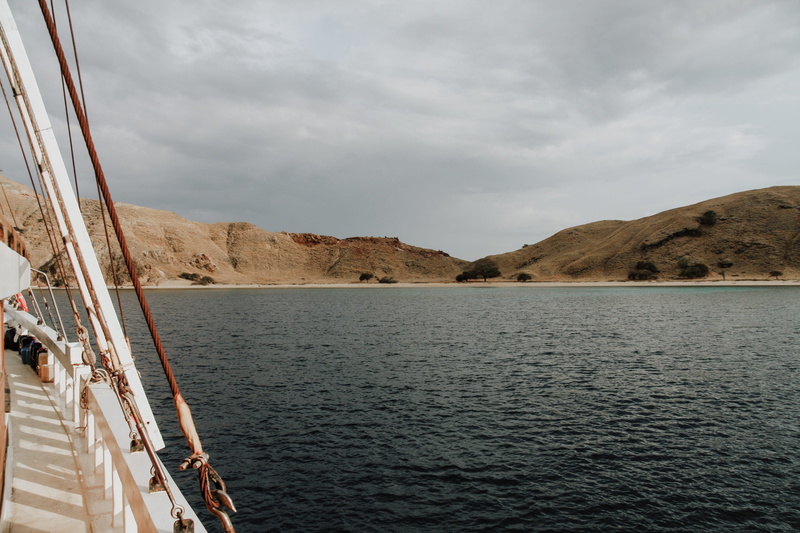 adventure, tranquility, sky, non-urban scene, tranquil scene, barge, boat, leisure activities, travel, vehicle, day, ocean, nature, mountain, slope, sailboat