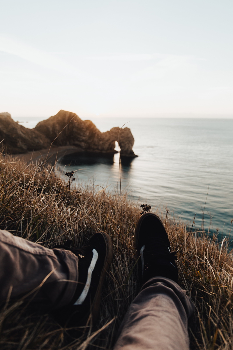 human limb, brown, beach, depth of field, personal perspective, sofa, shoe, tranquility, nature, mountain, water, scenics - nature, one person, body part