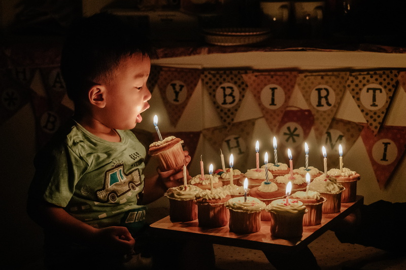 indoors, boy, birthday candles, sweet food, cupcake, banner, men, face, illuminated, males, food and drink, person, toddler, flame, born, birthday cake