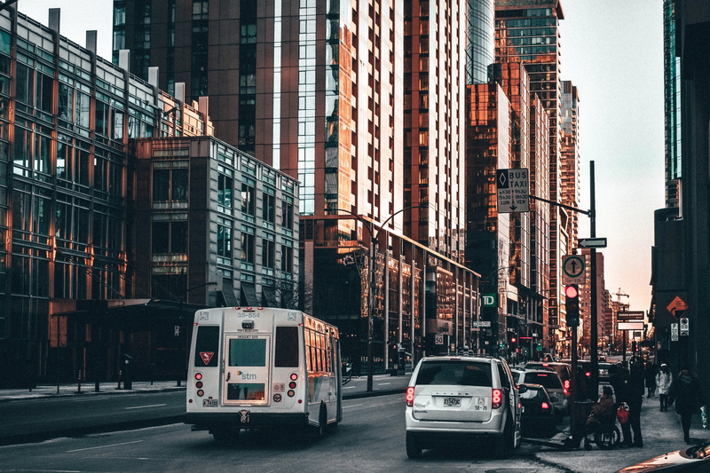 city street, office building exterior, vehicles, city life, architecture, building, incidental people, building exterior, buildinbgs, sorrounded, nature