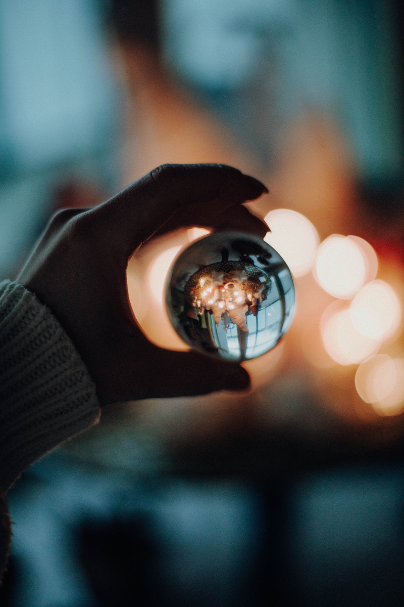reflection, holding, fashion, day, glass, close-up, human limb, ball, outdoors, nature, person, lights, fingers, focus on foreground, real people, indoors