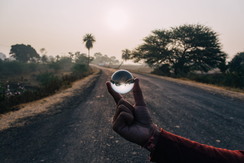 tar, human body part, focus on foreground, real people, sphere, nature, decor, human, sunglasses, light, holding, asphalt, accessory, human hand, road