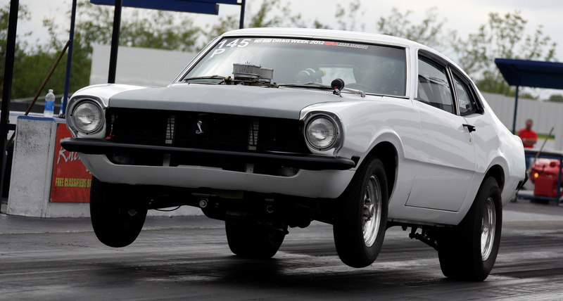 city, focus on foreground, mode of transportation, outdoors, 4K, parking, ford maverick, motor vehicle, retro styled, headlight, wheel, car, street, stationary