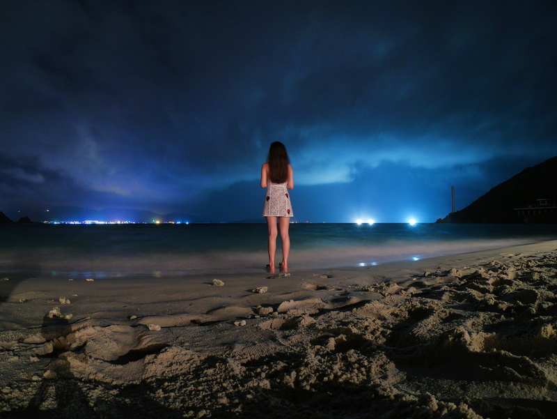 shoreline, human, ocean, solid, shorts, rock, coast, sky, full length, soil, nature, cloud - sky, illuminated, one person, rock - object, dirt road, flare