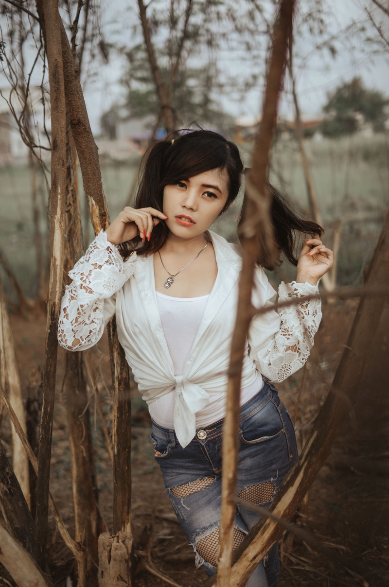 black hair, young adult, young women, white blouse, contemplation, lip, focus on foreground, trees, looking at camera, hairstyle, woods, photo, beautiful woman