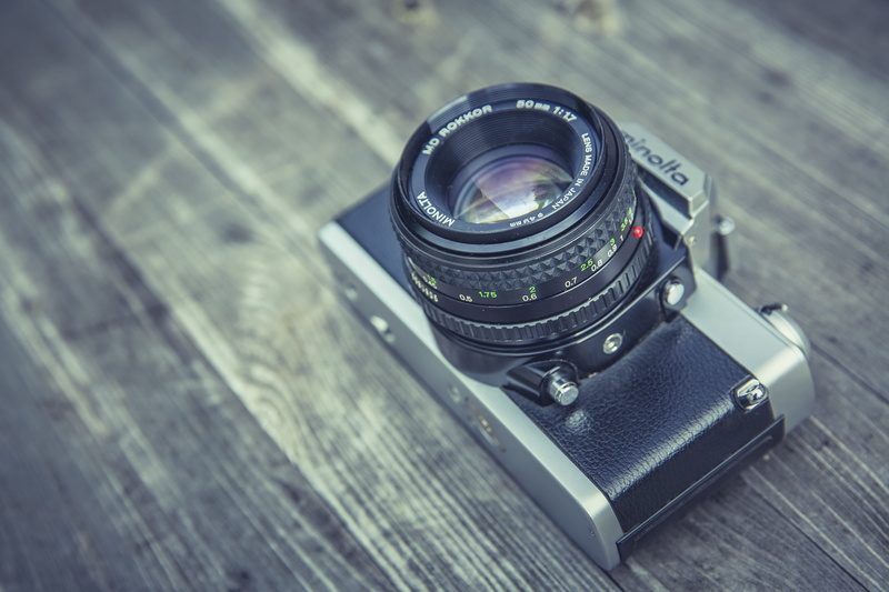 SLR, retro styled, grey, high angle view, single object, film industry, 5K, camera, table, focus on foreground, no people, wood - material, lens - eye