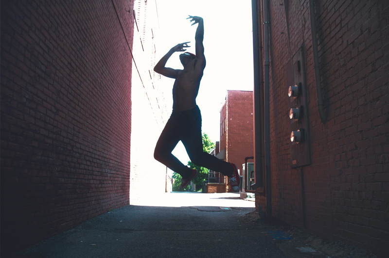 architecture, brick wall, built structure, jump, clarksville, human arm, brick, outdoors, arms raised, intense, express, art, dancing, outside, wall - building feature