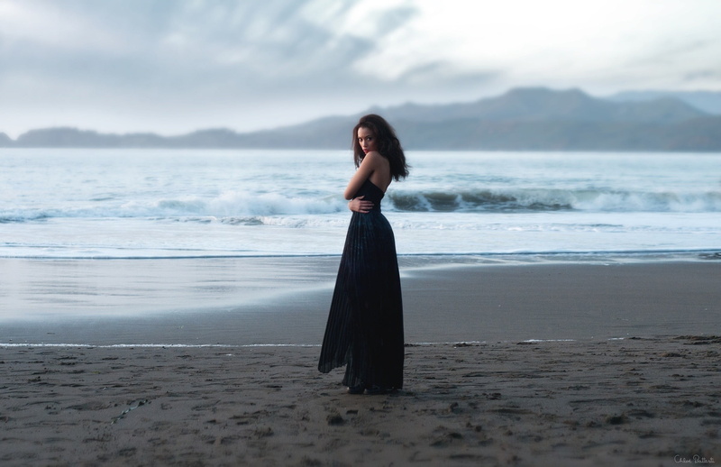 leisure activity, brunette, sand, beautiful woman, looking at viewer, young adult, sky, standing, real people, hairstyle, black dress, full length, dress