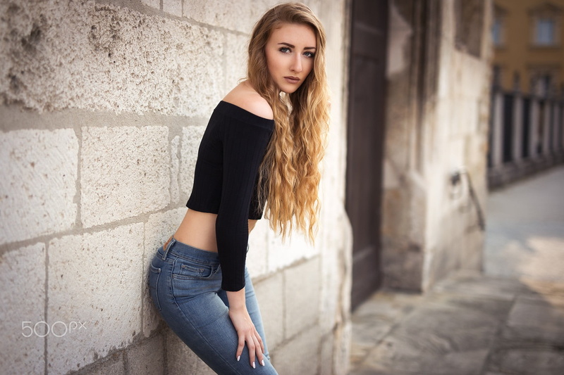 casual clothing, lifestyles, wall, three quarter length, pants, hairstyle, portrait, outdoors, contemplation, skinny, looking at camera, beauty, women