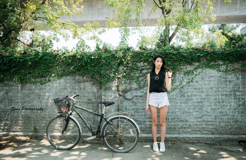jean shorts, outdoors, portrait, lifestyles, one person, tree, black hair, day, full length, Asian, standing, plants, wall, mode of transportation, plant