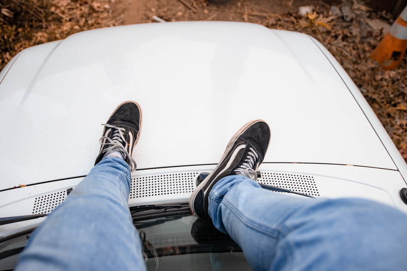high angle view, human body part, culture, men, van, hanging out, jeans, sitting, truck, one person, human foot, car, lifestyles, skinny jeans, outdoors