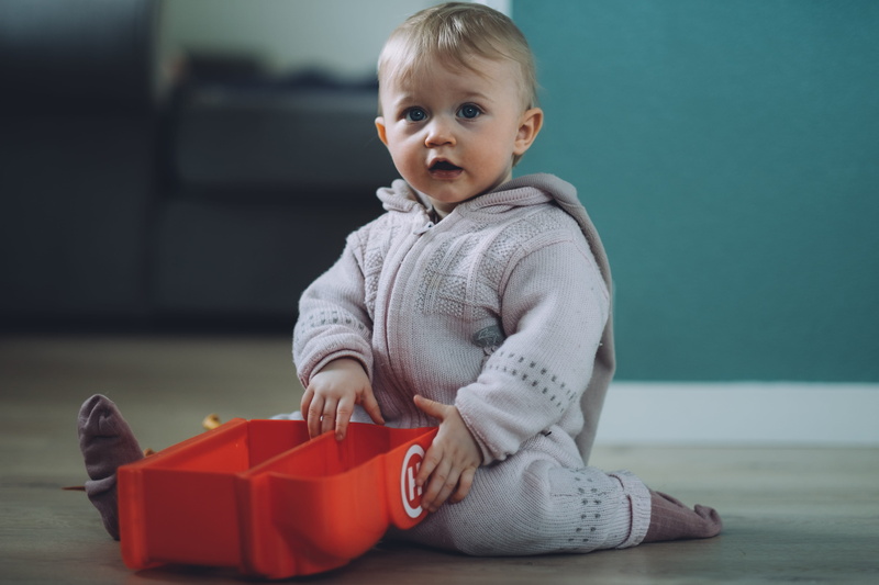 wearing, emotion, children, innocence, full length, red, toy, gift, sitting, baby, childhood, clothing, indoors, ground, case, focus on foreground, kid