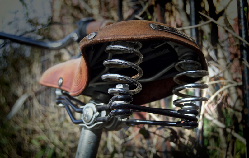focus on foreground, stainless steel, selective focus, absence, close up, rusty, blur, wheel, outdoors, plant, bicycle saddle, seat, mode of transportation