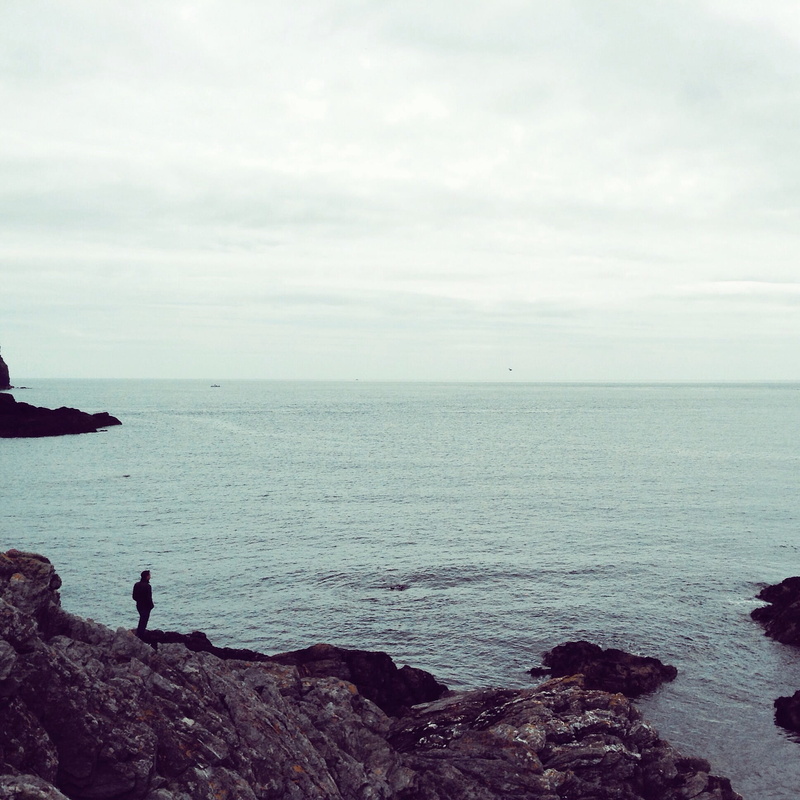 stones, outdoors, seascape, sky, land, tranquil, real people, one person, beach, calm, contemplation, lonely, shore, scenics - nature, leisure activity