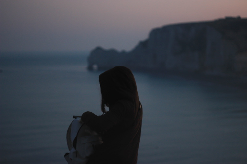 sea, hair, tranquil scene, ocean, backpack, france, one person, tranquility, sunset, real people, hood, lifestyles, bag, water, focus on foreground, nature