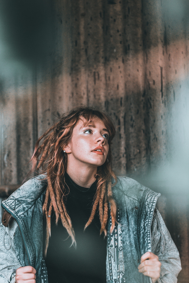 wall - building feature, front view, looking up, female, portrait, woman, leisure activity, fade, earring, holding, vintage, young women, brown hair, denim jacket