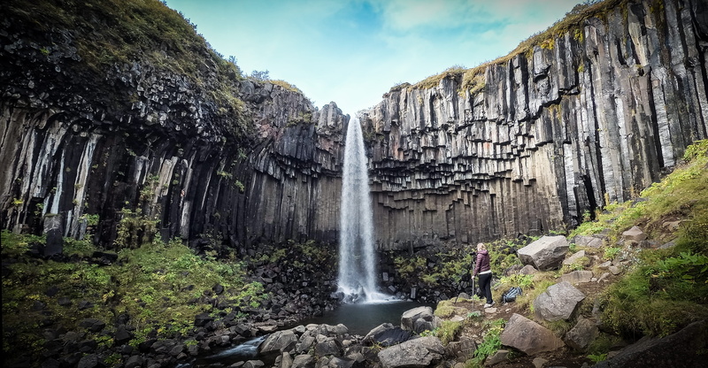 non-urban scene, panoramic, scenics - nature, svartifoss, landscape, iceland, flowing water, rock - object, blue, solid, human, formation, rock, outdoors