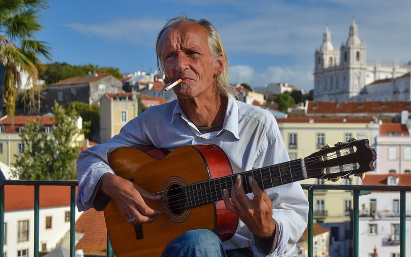 building exterior, music, real people, string instrument, one person, casual clothing, adult, 1080P, musical instrument, senior adult, musical equipment