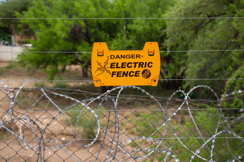 sign, road sign, symbol, stopsign, word, animal, information sign, focus on foreground, wire, outdoors, invertebrate, electric fence, namibia, barrier