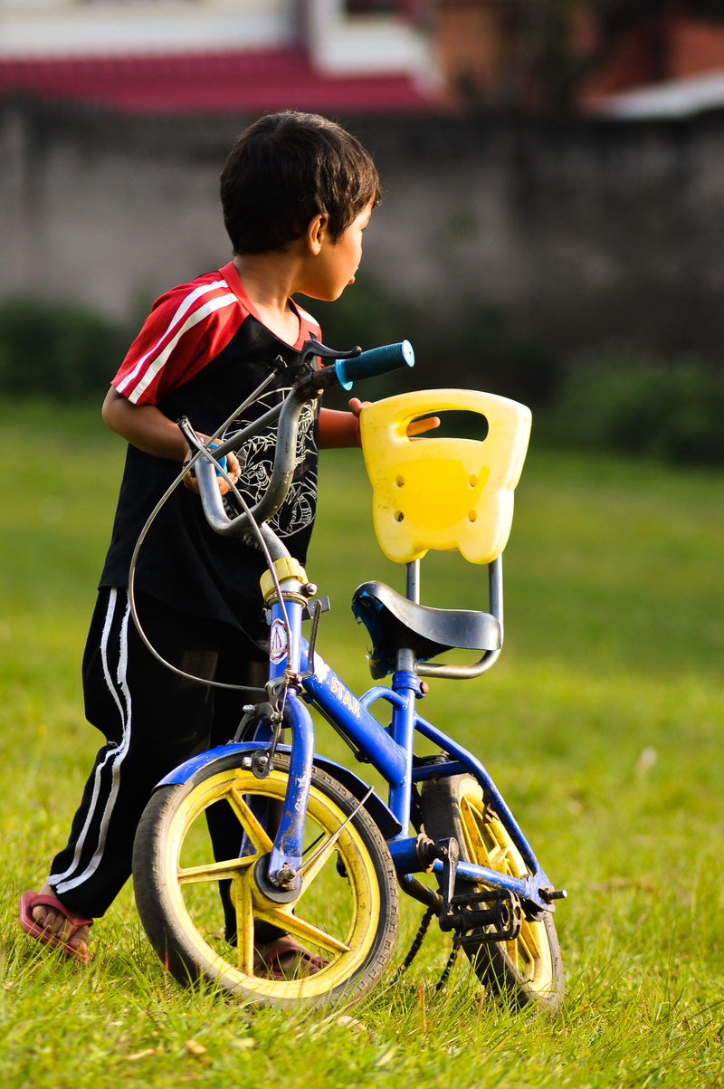 casual clothing, focus on foreground, boys, innocence, leisure activity, grass, land, day, plant, real people, nature, cycle, india, males, men, age, playground