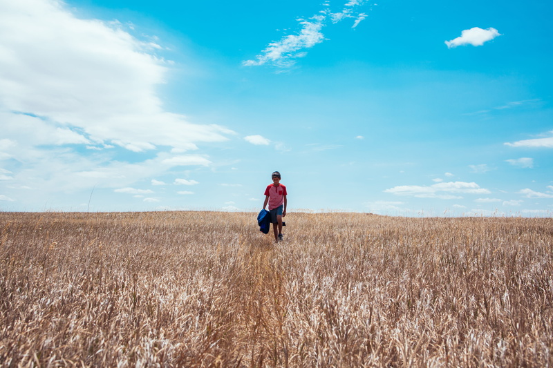 casual clothing, west, lifestyles, wildlife, field, badlands, lonely, walking, depressed, child, sky, alone, real people, boy, tranquil scene, wildwest