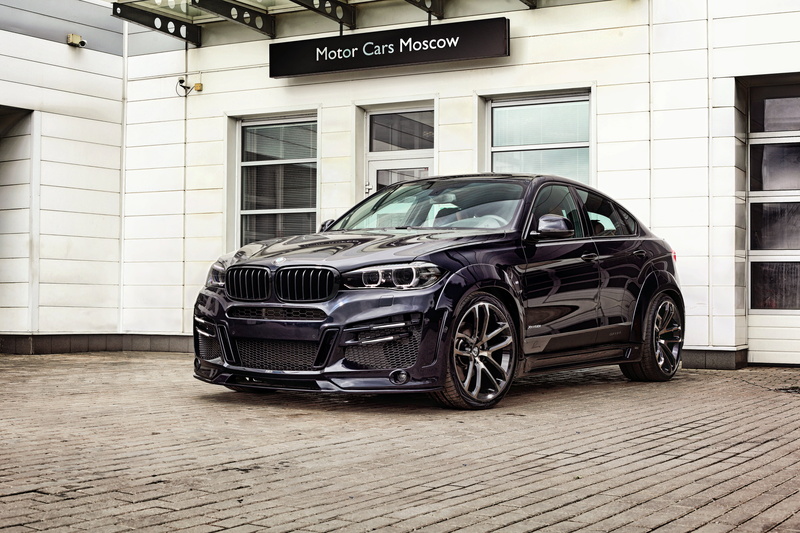 black, wheel, land vehicle, BMW, outdoors, luxury, parking, sign, car, clean, glass - material, F16, sedan, no people, city, building exterior, lumma design