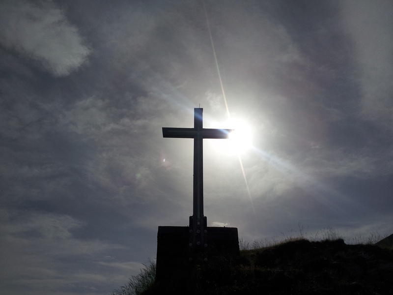 crucifix, architecture, cloud - sky, spirituality, summit, sunlight, built structure, alpine, belief, sun, daytime, religion, cross shape, outdoors, sunbeam