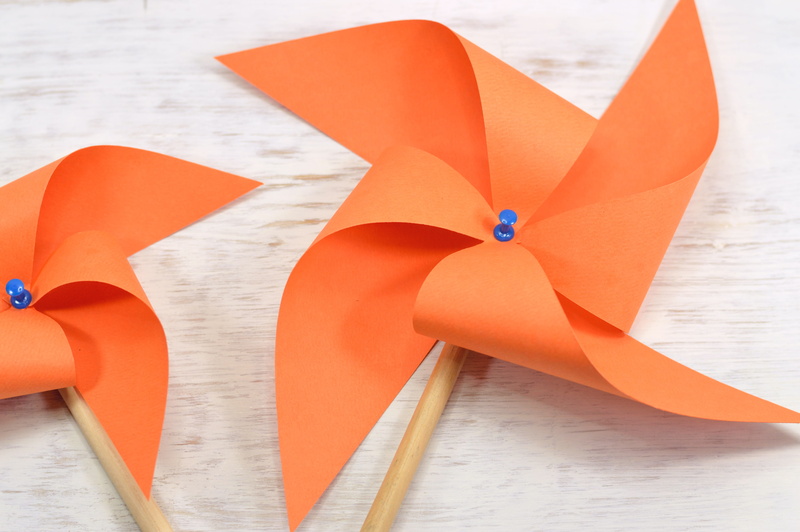 outdoors, close-up, no people, pinwheel toy, focus on foreground, curve, multi colored, rehilete, group of objects, paper, creativity, nature, giro, mill