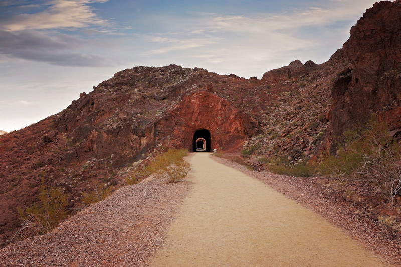 outdoors, cloud - sky, sky, desert, rock formation, travel, road, rock, bridge, one person, scenic, rear view, tunnel, mountain, wonder, nature, railroad trail