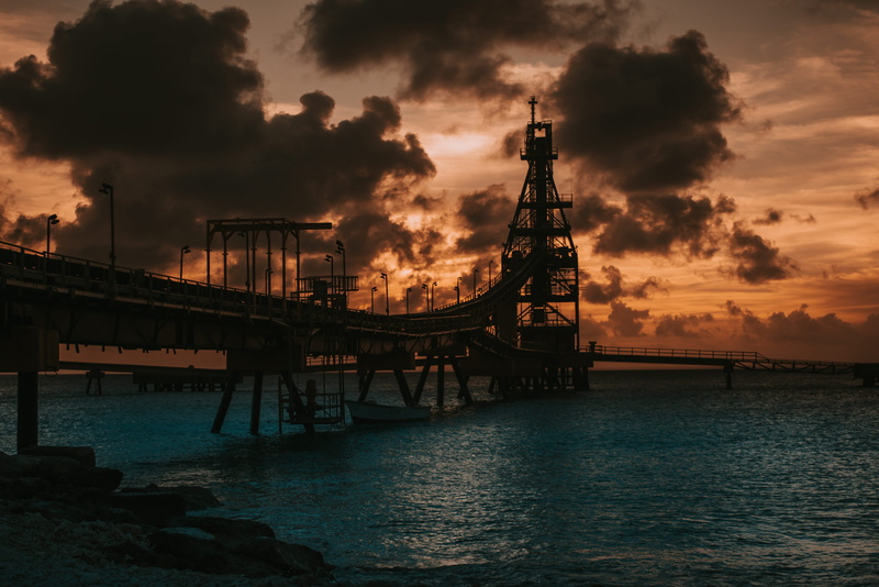 dock, bridge, mode of transportation, nature, outdoors, port, connection, silhouette, building, building exterior, dusk, sky, sunset, architecture, sea