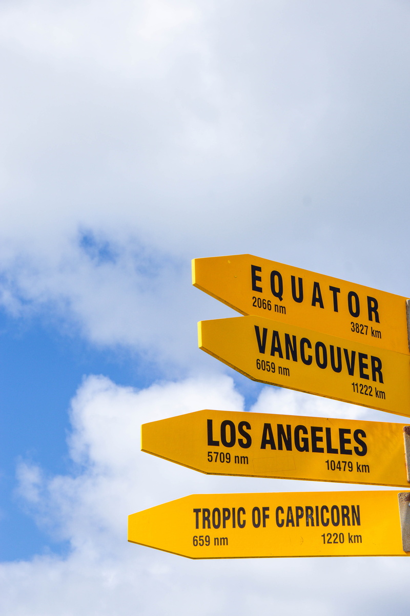 day, building, construction crane, urban, signages, arrow, yellow, roller coaster, emblem, wedge, cloud - sky, street, communication, town, western script