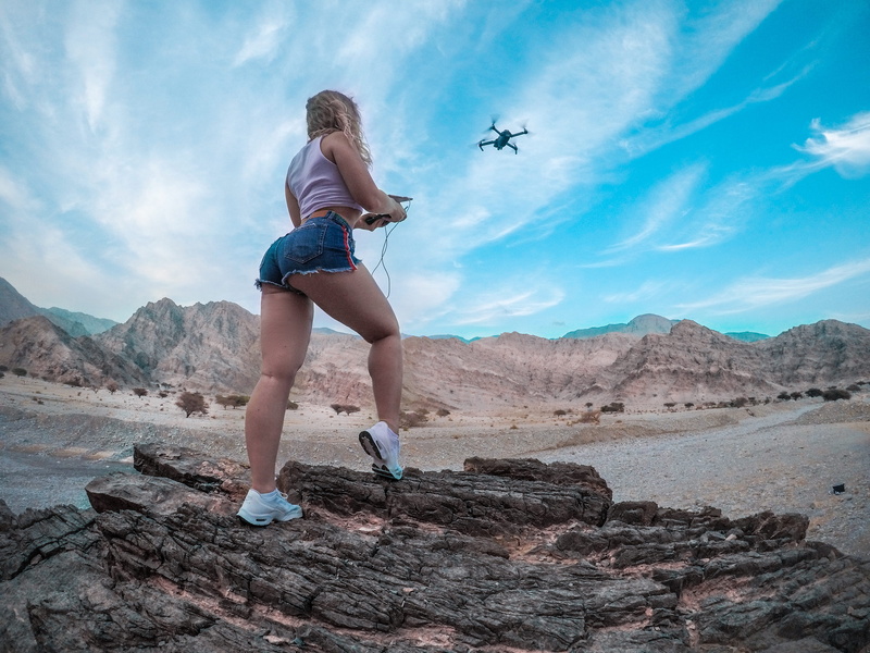 cloud - sky, shorts, beauty in nature, adult, landscape, mountain, young women, flying drone, one person, hobby, low angle shot, exercising, healthy lifestyle