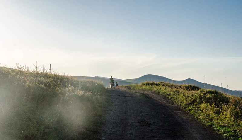 clouds, scenics - nature, sky, day, the way forward, road, outdoors, dirt, non-urban scene, dirt road, riding, tranquility, nature, hill, people, fog, person