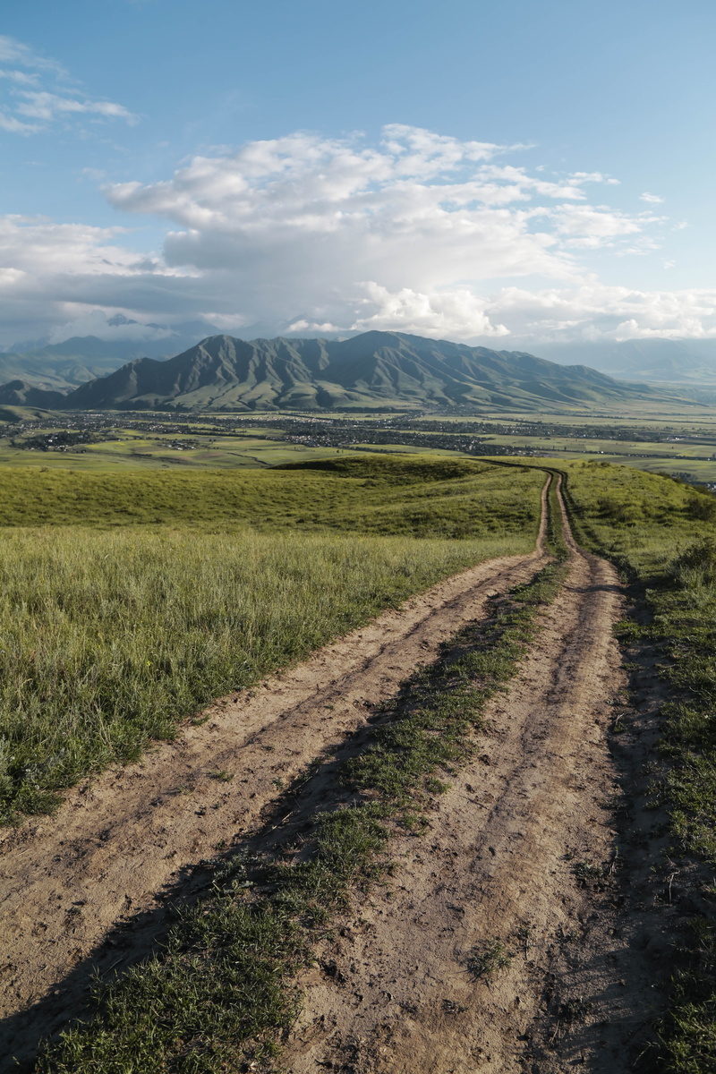 mountain, middle, grassland, nature, transportation, grass, road, growth, beauty in nature, non-urban scene, tranquility, the way forward, cloud - sky