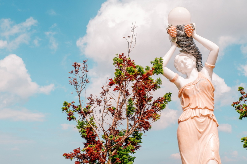 Cebu, no people, tree, male likeness, religion, temple of leah, statue, belief, outdoors, low angle view, female likeness, woman, day, creativity, cloud - sky