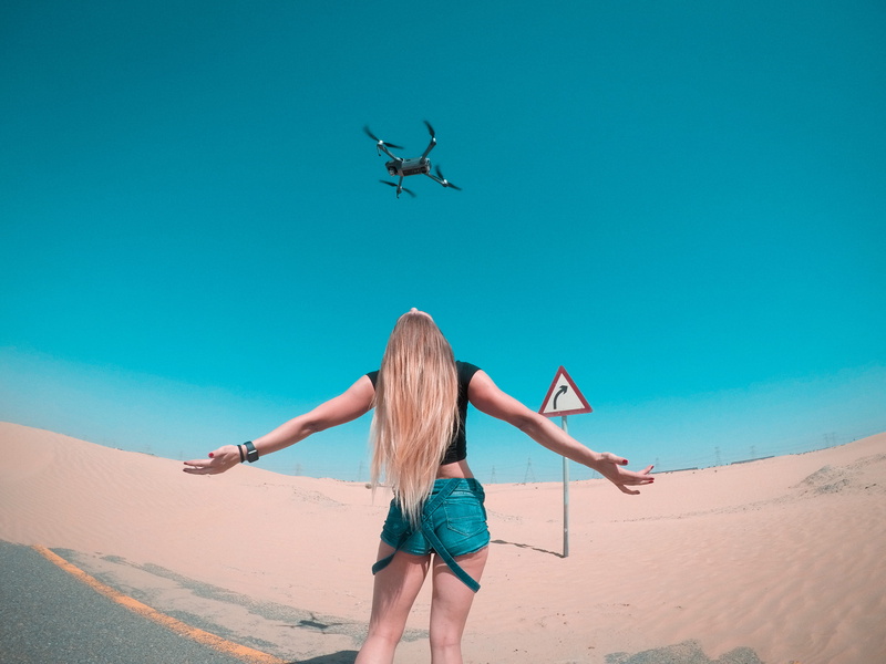 hair, camera, wearing, nature, women, human arm, lifestyles, leisure activity, casual clothing, young women, hairstyle, drone, outdoors, desert, adult