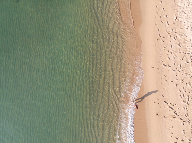 near, drone photography, walking, shore, outdoors, beach, travel destinations, standing, beauty in nature, person, high angle view, water