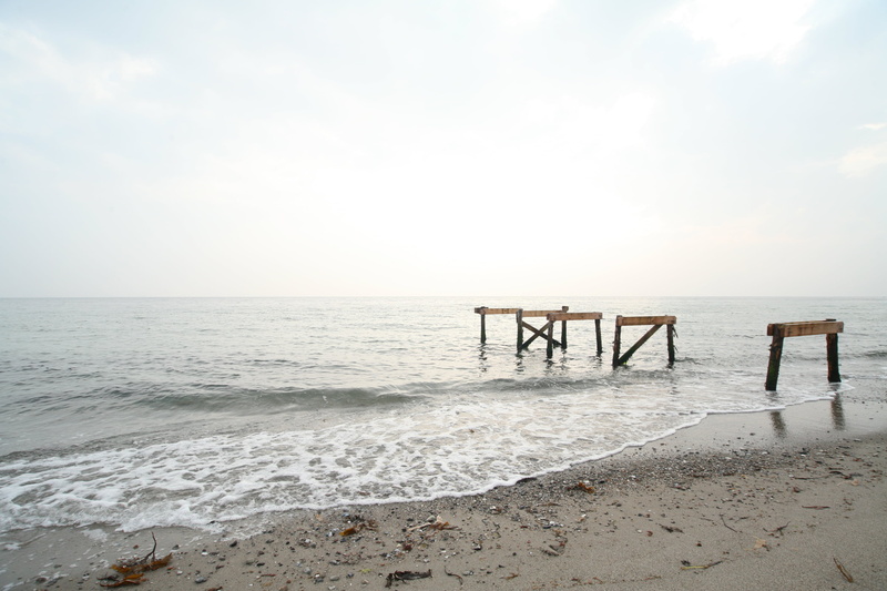 sand, horizon over water, beauty in nature, seascape, water, ocean, land, cloud - sky, beach, scenics - nature, wooden post, tranquil scene, outdoors, bridge