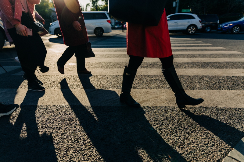pedestrian, footwear, along, shadow, road, mode of transportation, human, person, asphalt, suv, vehicle, sunlight, lane, leisure activities, adult, group of people