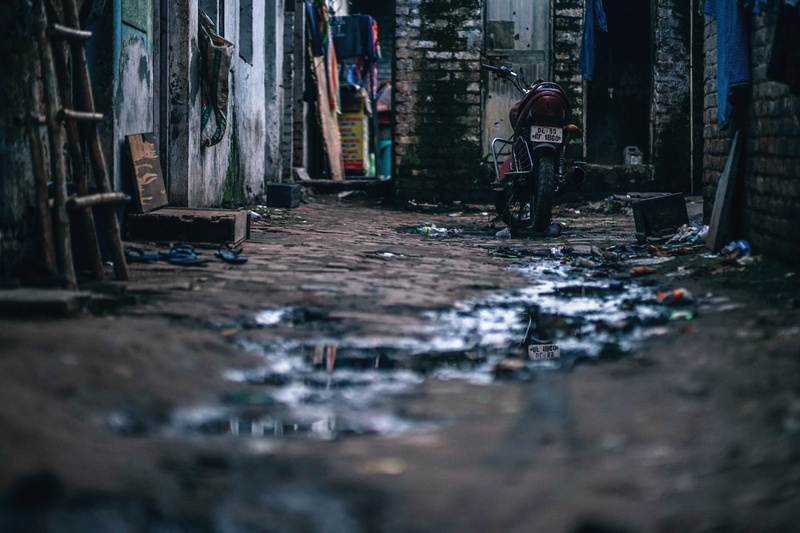 surface level, middle, urban, waste, footpath, 5K, messy, outdoors, exterior, street, passage, dirty, standing, narrow, houses, building, parked, outdoor
