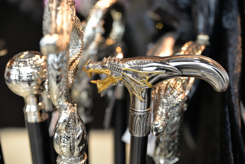 walking stick, retail, subculture, focus on foreground, colored, handle, indoors, steampunk, outfit, luxury, gold colored, cane, silver colored, close-up
