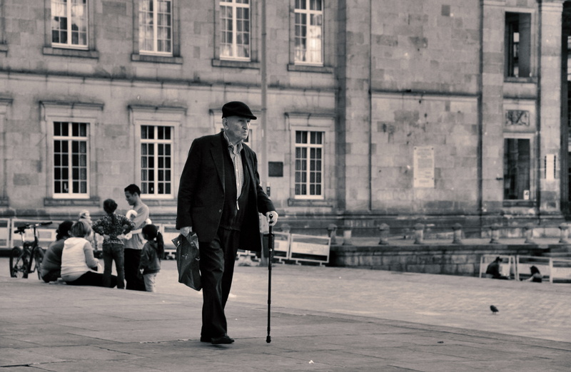 5K, photography, building exterior, walking, walking cane, day, cane, grayscale, city life, adult, full length, built structure, real people, outdoors