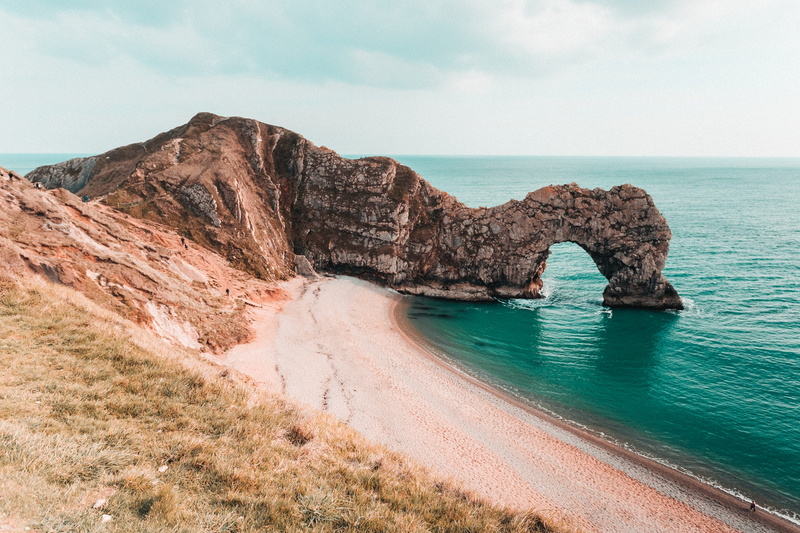 rock, no people, outdoors, tranquil scene, sea, durdle door, beauty in nature, cave, cloud - sky, green, water, sky, sand, scenics - nature, arch, nature