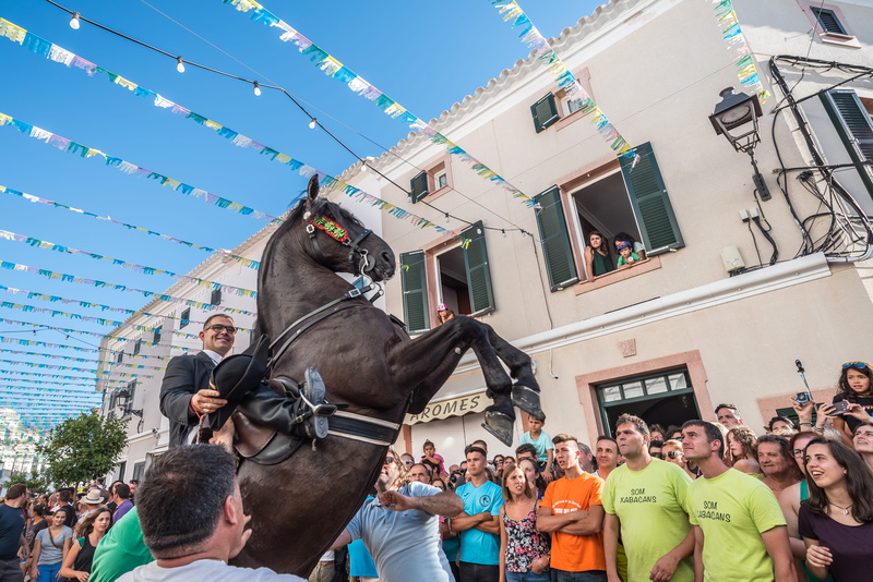 built structure, domestic animals, buck, stallion, es mercadal, men, city, festival, large group of people, crowd, mammal, 5K, menorca, day, outdoors