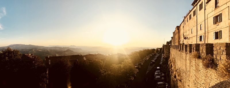 travel destinations, outdoors, mountain, building, travel, parking, no people, town, sunset, nature, sunlight, sunbeam, sky, built structure, lens flare