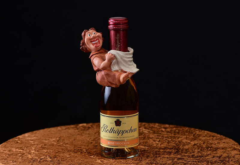 bottle, humor, celebrate, front view, funny, drink, prost, human limb, ready-to-eat, indoors, alcohol, still life, table, holding, figure, black background