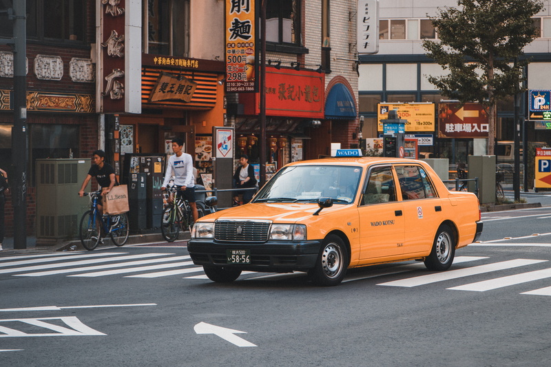 japan, city, real people, built structure, road marking, land vehicle, shop, communication, street, mode of transportation, road, yellow, outdoors, cab